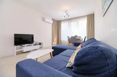a living room with a blue couch and a tv at Cozy 1-bed Apartment in Plovdiv