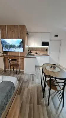 a room with a bed and a table and a kitchen at Monfort A in Bansko