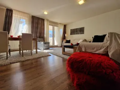 a living room with a bed and a red rug at Bansko Royal Towers - 2BD Flat with Parking by Flat Mаnager in Bansko