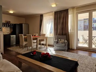 a living room with a table and a dining room at Bansko Royal Towers - 2BD Flat with Parking by Flat Mаnager in Bansko