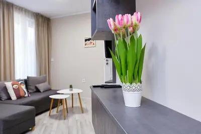 a vase of pink flowers on a counter in a living room at Cozy 1-bed Apartment 2 in Plovdiv