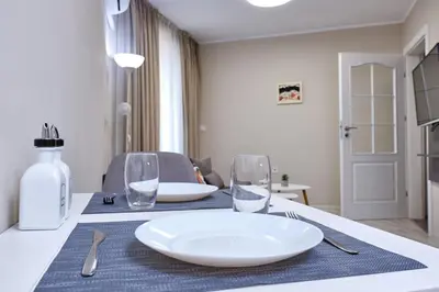 a table with a white plate and glasses on it at Cozy 1-bed Apartment 2 in Plovdiv