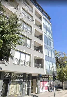 a tall white building on the corner of a street at Cozy 1-bed Apartment 2 in Plovdiv