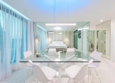 a dining room with a glass table and white chairs at Emirates White Sensation in Sofia