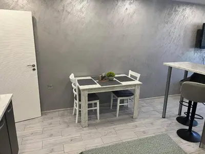 a dining table and chairs in a room with a wall at Ultra Lux Studio Free Underground Secure Parking in Pazardzhik