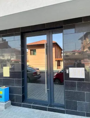 a glass door of a building with a reflection of a car at Ultra Lux Studio Free Underground Secure Parking in Pazardzhik