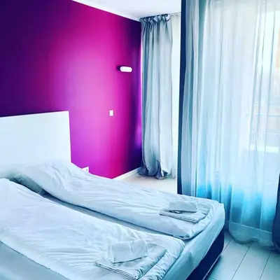 a bed in a room with a pink wall at Magenta Apartment with free WiFi in Sofia
