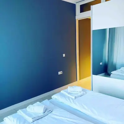 a bedroom with a bed with a mirror and towels at Magenta Apartment with free WiFi in Sofia
