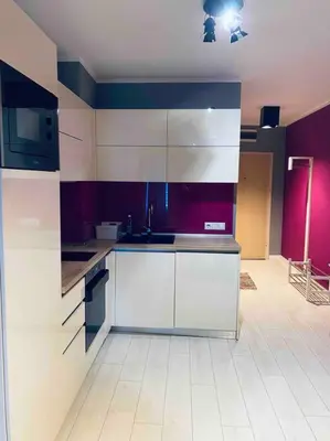 a kitchen with white cabinets and purple walls at Magenta Apartment with free WiFi in Sofia