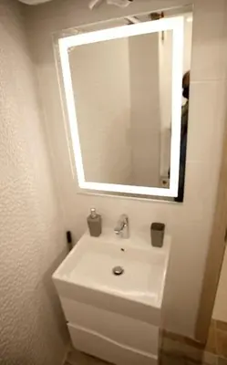 a white bathroom with a sink and a mirror at Magenta Apartment with free WiFi in Sofia