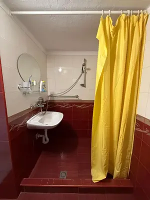 a bathroom with a yellow shower curtain and a sink at Вила за гости “Попина лъка” in Vikhren