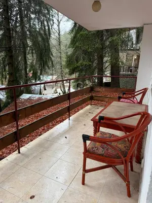a patio with two chairs and a table on a balcony at Вила за гости “Попина лъка” in Vikhren