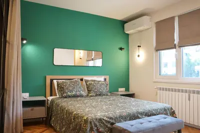 a green bedroom with a bed and a mirror at Stylish and Quiet Apt with Balcony in Sofia