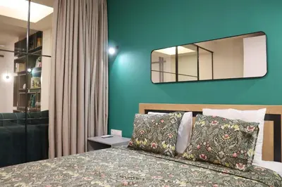 a bedroom with a bed and a blue wall at Stylish and Quiet Apt with Balcony in Sofia