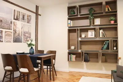 a dining room with a table and chairs and a book shelf at Stylish and Quiet Apt with Balcony in Sofia