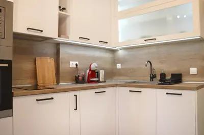 a kitchen with white cabinets and a sink at Stylish and Quiet Apt with Balcony in Sofia