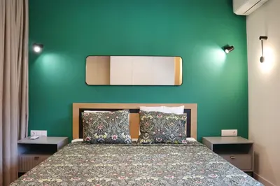 a bedroom with a bed with a green wall at Stylish and Quiet Apt with Balcony in Sofia
