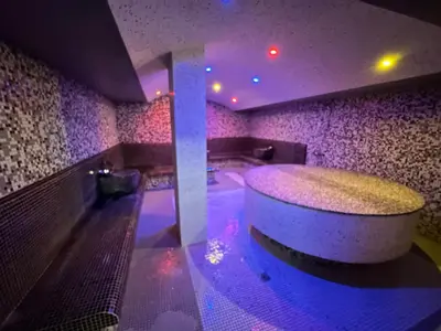 a swimming pool with a tub in a room with purple lights at Nice apartment in Belvedere Club in Bansko