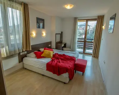 a living room with a couch with a red blanket on it at Banderitsa Apartment 1 in Bansko