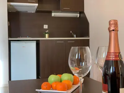 a bottle of wine and two wine glasses on a table at Banderitsa Apartment 1 in Bansko