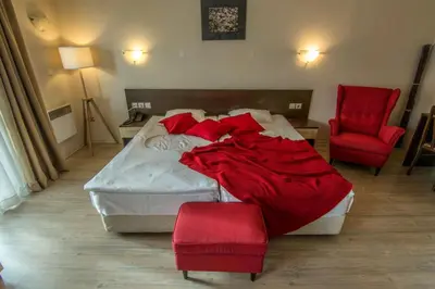 a bedroom with a large bed with red pillows at Banderitsa Apartment 1 in Bansko