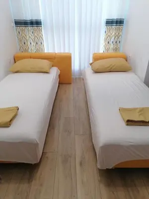 two beds in a room with a wooden floor at Студио Ели - Пловдив in Plovdiv