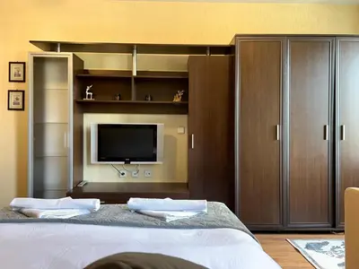 a bedroom with a large bed with a tv on it at Private Suite at Comfort Bansko in Bansko