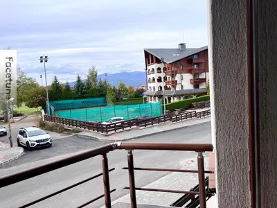 a balcony with a car parked on a city street at Private Suite at Comfort Bansko in Bansko