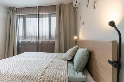 a bedroom with a bed with a lamp and a window at Your Place in Sofia