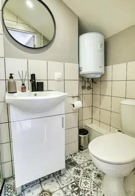 a bathroom with a toilet and a sink and a mirror at Lily's Studio 1 by Bulgarentals - Central Sofia in Sofia