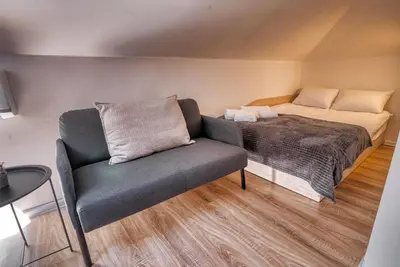 a bedroom with a bed and a couch in it at Lily's Studio 7 by Bulgarentals - Central Sofia in Sofia