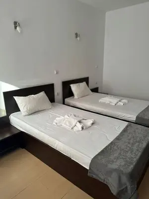 two beds in a room with towels on them at Хотел Костенец in Kostenets Village