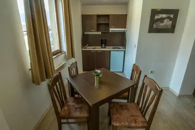 a dining room with a table and chairs and a kitchen at Banderitsa Studio Bansko 2 in Bansko