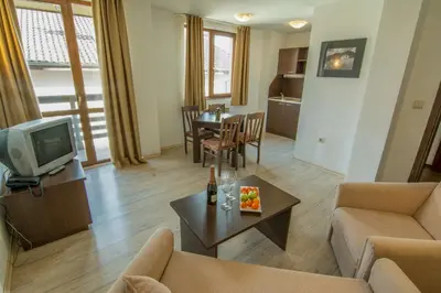 a living room with a couch and a tv and a table at Banderitsa Studio Bansko 2 in Bansko