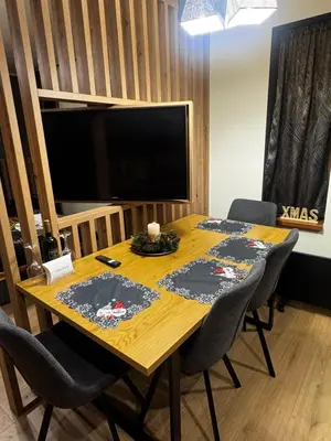 a dining room table with chairs and a television at Avelov Art Studio in Pamporovo