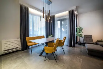 a dining room with a table and yellow chairs at ARHEYA 1 apart Архея 1 апартамент за гости in Karlovo