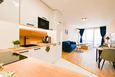 a kitchen and living room with a table and a couch at Armand de Azurro in Sofia