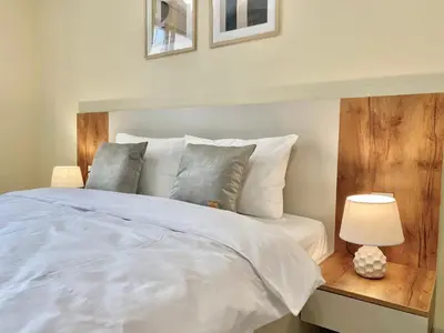 a bedroom with a white bed and a table with a lamp at Beautiful & Comfy Apartment for 4 Guest and Free Parking in Plovdiv