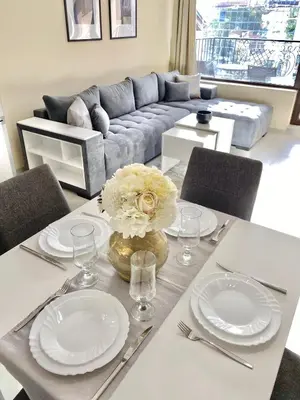 a dining table with white plates and a vase of flowers at Beautiful & Comfy Apartment for 4 Guest and Free Parking in Plovdiv
