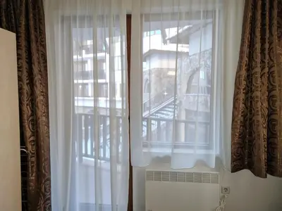 a window with white curtains in a room at апартаменти Уют Гранд Манастира in Pamporovo