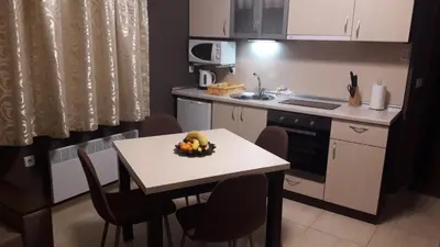 a kitchen with a table with a bowl of fruit on it at апартаменти Уют Гранд Манастира in Pamporovo