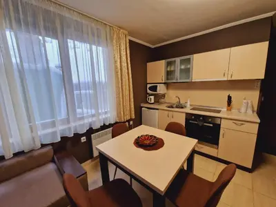 a small kitchen with a table and chairs in a room at апартаменти Уют Гранд Манастира in Pamporovo