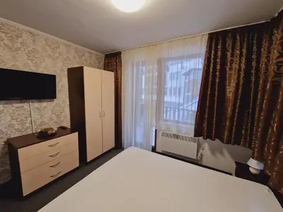 a bedroom with a bed and a dresser and a window at апартаменти Уют Гранд Манастира in Pamporovo