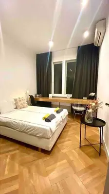a bedroom with a bed and a table and a window at Heart of the city in Sofia