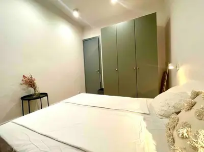 a bedroom with a large white bed with a green cabinet at Heart of the city in Sofia