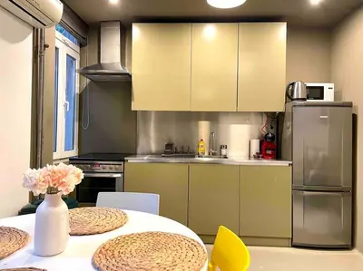 a kitchen with a table with chairs and a refrigerator at Heart of the city in Sofia