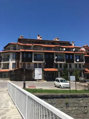 a white car parked in front of a building at One bedroom apartment in Hotel Banderitsa ,Bansko in Bansko