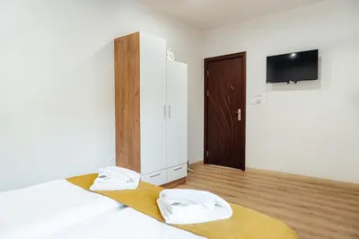 a bedroom with two beds and a flat screen tv at VILLA MEDI boutique in Sapareva Banya