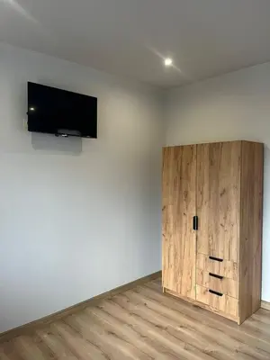 a room with a wooden door and a television on a wall at VILLA MEDI boutique in Sapareva Banya