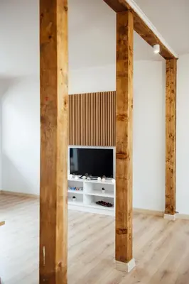 a living room with a tv and wooden beams at VILLA MEDI boutique in Sapareva Banya
